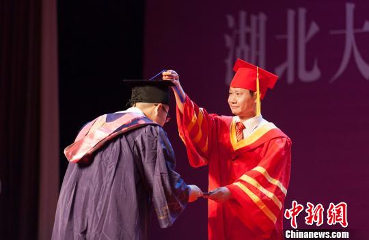 图为,必赢76net线路官网校长赵凌云为毕业生拨穗正冠 向正鹏 摄 图为,必赢76net线路官网校长赵凌云为毕业生拨穗正冠 向正鹏 摄